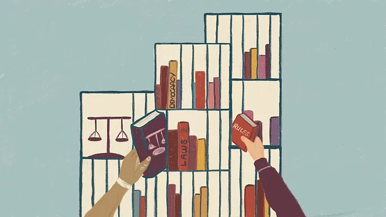 This illustration shows a scene in front of a bookshelf, in which two people are reaching out to grab books with titles such as Democracy, Laws and  Rules.